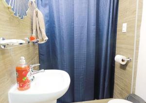 Un baño con una cortina de ducha azul y un inodoro. en Alameda Suites & CAS - Centro Monterrey, en Monterrey 29 fotos más