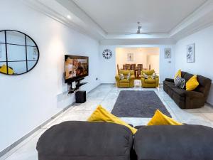 a living room with two couches and a tv at The Glenn House in Apenkwa