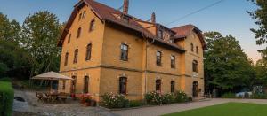 a large brick building with flowers in front of it at Ferienhaus Alter Bahnhof Stötteritz in Leipzig