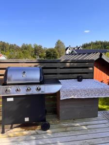 a barbecue grill on a deck with a roof at Magnolia in Älvsered