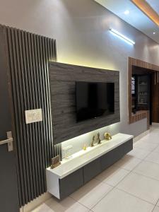 a bathroom with a sink and a television on a wall at 2BHK Family Haven with Spacious and Scenic Views in Pathānkot