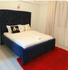 a bed with a black headboard and a red rug at Mango Court in Nairobi