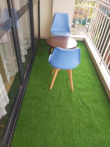 two blue chairs and a table on a green floor at Mango Court in Nairobi