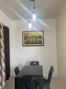 een eetkamer met een tafel en een schilderij aan de muur bij Whole Furnished House with Parking and Sea View in Tagibo