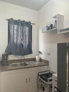 een keuken met een spoelbak en een aanrechtblad bij Whole Furnished House with Parking and Sea View in Tagibo