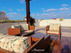 a patio with furniture and a table and chairs at One Cabo Branco-Poucos Metros da Praia in Tambaú