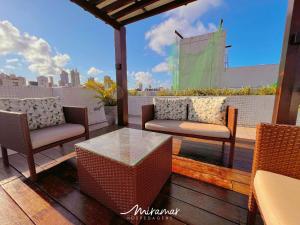 a patio with two chairs and a table on a balcony at One Cabo Branco-Poucos Metros da Praia in Tambaú