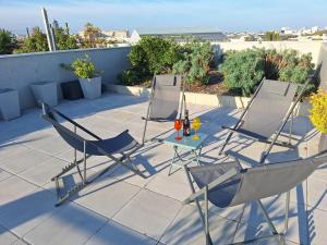a patio with two chairs and a table with drinks at Appartement 97m2-Roof Top privé 100m2-Parking privé-Clim mobile in Nantes