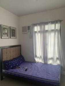 een slaapkamer met een bed met paarse lakens en een raam bij Whole Furnished House with Parking and Sea View in Tagibo