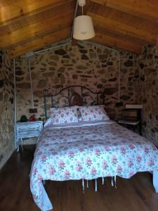 a bedroom with a bed in a stone wall at La Casa de la Fuente 