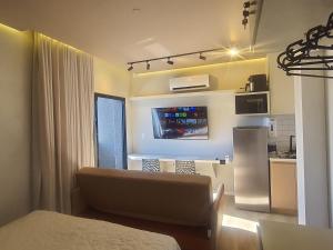 a living room with a couch and a kitchen at Apart-hotel Theotókos Flats in Piauí