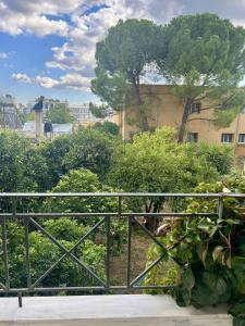 a balcony with a fence and a tree at Vintage house overlooking the statue of Leonidas in Sparti
