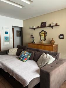 un salon avec un canapé et un miroir dans l'établissement Espaço inteiro com 3 quartos não compartilhado com outros no centro, à Miguel Pereira 27 autres photos