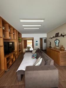 un salon avec un canapé et une télévision dans l'établissement Espaço inteiro com 3 quartos não compartilhado com outros no centro, à Miguel Pereira