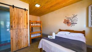 a bedroom with a bed and a wooden door at Cerrado 07 - Suítes individuais em pousada in Pirenópolis