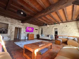 a living room with a couch and a table at Maison de L'Olivier in Saint-André-et-Appelles
