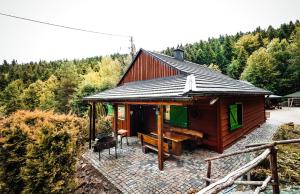 a small cabin with a bench and a table at Świerkowe Zacisze Domki in Budzów