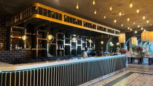 a bar in a restaurant with people sitting at tables at Gold Crest Luxury Hotel Apartments-City View DHA Lahore in Lahore