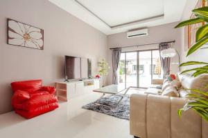 a living room with a couch and a red chair at 派对家园-11卧室独栋大泳池私密别墅 in Ban Huai Yai