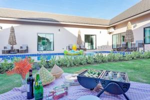 a patio with a table with a bowl of fruit and wine bottles at 派对家园-11卧室独栋大泳池私密别墅 in Ban Huai Yai