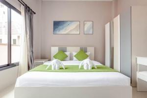 a bedroom with a large white bed with green pillows at 派对家园-11卧室独栋大泳池私密别墅 in Ban Huai Yai +55 photos