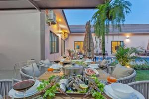 a table with food on top of a patio at 派对家园-11卧室独栋大泳池私密别墅 in Ban Huai Yai
