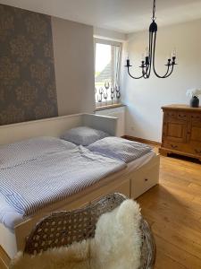 a bedroom with a bed and a chair and a window at Ferienwohnung in Kürten