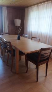 a large wooden table with chairs and a lamp at Helle Ferienwohnung auf BIO-Bauernhof in Grabs