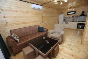 ein Wohnzimmer mit Sofa und Tisch in der Unterkunft Cottage in Forest Wave - კოტეჯი ტყის ტალღებში in Grigoleti