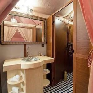 a bathroom with a sink and a mirror at Merzouga traditional Camp in Merzouga