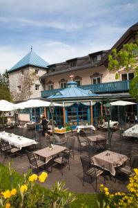 un groupe de tables et de chaises devant un bâtiment dans l'établissement Gasthof Schorn, à Sankt Leonhard