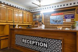 a woman is sitting at a reception desk at Hotel Krone Near IGI Airport Delhi in New Delhi