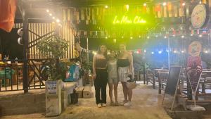 grupa trzech kobiet stojących przed barem w obiekcie La Mai Chau Home Food & Coffee w mieście Mai Châu