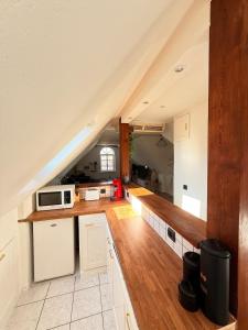 アグノーにあるAppartement Cosy et Confort - Vues et situation exceptionnellesの屋根裏のキッチン(白いキャビネット、電子レンジ付)