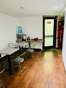 Il comprend une cuisine équipée de tables, de chaises et d'un réfrigérateur. dans l'établissement Unicentro Rooms Inn by Saint Michel, à Bogotá