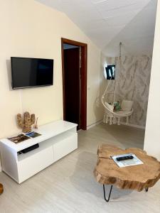 Una sala de estar con televisión y una mesa de café. en Sebastian's Apartment, en São Vicente 4 fotos más