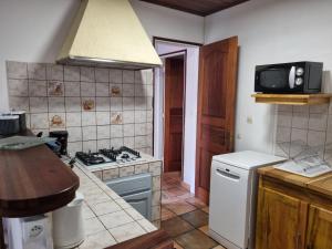 a kitchen with a stove and a sink and a refrigerator at COSY Montagne in Cilaos +8 photos