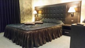 a bedroom with a large bed with a leather headboard at Hotel Chamishki in Blagoevgrad