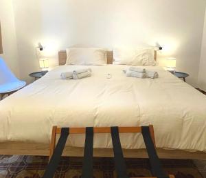 Una cama blanca grande con dos toallas encima. en Le Ville Tivoli - Adriana, en Tívoli