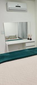 a mirror in a room with a green rug at Apartamento na praia in Itapema