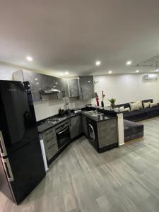 a kitchen with black and white appliances in a room at Mehdia's Paradise in Kenitra