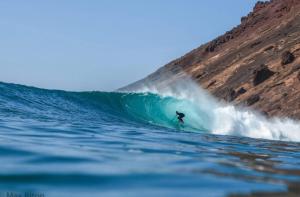 a person riding a wave on a surfboard in the ocean at Casa Marina in Lajares