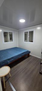 a small room with a bed and two windows at Casa del Viento y la Lluvia House of Wind and Rain in Tilarán