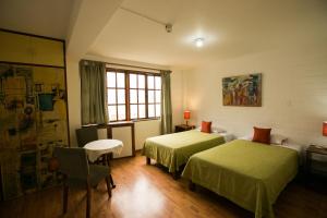 een hotelkamer met twee bedden en een raam bij Casa de Baraybar in Lima