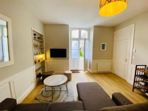 un salon avec un canapé et une table dans l'établissement Le Gîte Du Parc avec parking vieux port et plage au calme, à La Rochelle 21 autres photos