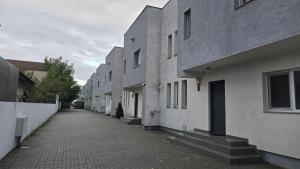a row of white buildings on a street at Casa 2 Magurele in Măgurele