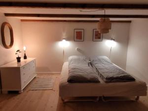- une chambre avec un lit, une commode et des lumières dans l'établissement Villa Fuga kælderlejlighed, à Jelling