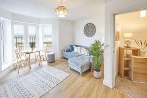 Una sala de estar con un sofá azul y una mesa. en Glenholme Apartments with Sea Views and Balconies in Redcar North Yorkshire, en Redcar