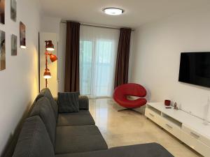 a living room with a couch and a red chair at Carvajal casa Tucan in Fuengirola