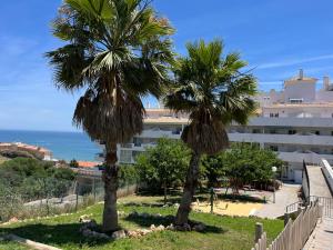 two palm trees in front of a building at Carvajal casa Tucan in Fuengirola